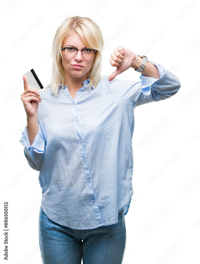 Sticker young beautiful blonde business woman holding credit card over isolated background with angry face, 