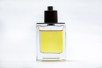 boccetta di profumo, fatta di vetro trasparente, contenente del liquido colore giallo, su sfondo bianco