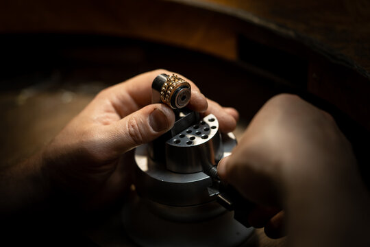 Jeweler puts diamond to golden wedding luxury ring.