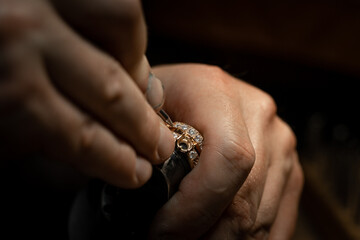 Jeweler puts diamond to golden wedding luxury ring.