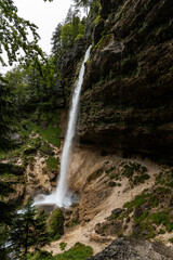 Perichnik waterfall is a beautiful drop from the mountain cliff, in Triglav National Park. Slovenian waterfall. Long for walking and trekking, enter inside the cave to admire it. Power and majesty.