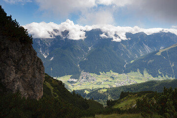 Stubai Valley seen from a mountainside near Fulpmes and Neustift, just below a thick layer of clouds, capturing the alpine scenery.
