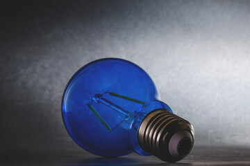 lampadina ad incandescenza di colore blu su sfondo sfuocato e sfumato di bianco e nero