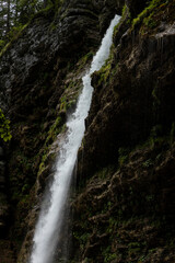 Obraz premium Perichnik waterfall is a beautiful drop from the mountain cliff, in Triglav National Park. Slovenian waterfall. Long for walking and trekking, enter inside the cave to admire it. Power and majesty.