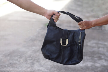 Thief hand  snatching the bag  from woman. Concept, Criminal pickpocket and crimes. Snatcher...