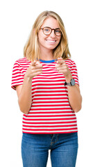 Beautiful young woman wearing glasses over isolated background pointing fingers to camera with happy and funny face. Good energy and vibes.