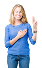 Beautiful young woman wearing blue sweater over isolated background Swearing with hand on chest and...