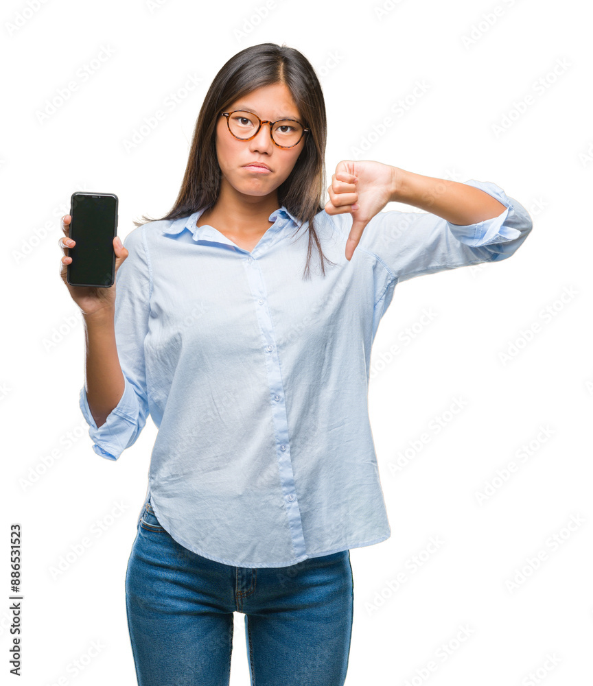 Poster Young asian woman showing smartphone blank screen over isolated background with angry face, negative sign showing dislike with thumbs down, rejection concept