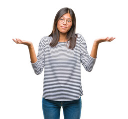 Young asian woman wearing glasses over isolated background clueless and confused expression with...