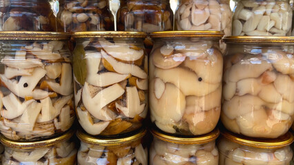 There are a lot of different canned mushrooms in jars. Canned mushrooms. Picking and storing mushrooms. Mushroom delicacies.