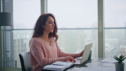 Focused freelancer typing computer at city view closeup. woman sipping coffee