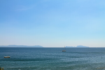 Two sailboats on the sea on the mountains background in Italy, the Bay of Naples