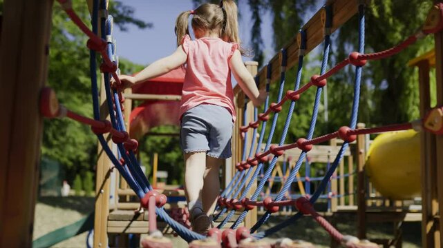 Happy Girl Playing on the Swing Set in the Playground