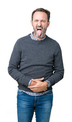 Fototapeta premium Handsome middle age senior man wearing a sweater over isolated background sticking tongue out happy with funny expression. Emotion concept.