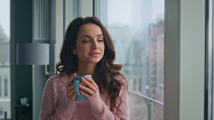 Peaceful woman sipping tea looking panoramic window morning closeup. Dreamy girl