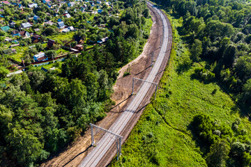 Aerial view of an electrified railway going around a bend in the countryside