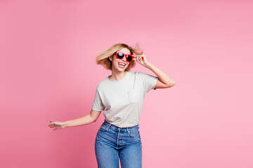 Photo of cheerful charming adorable girl wear stylish grey clothes dance chill empty space isolated on pink color background