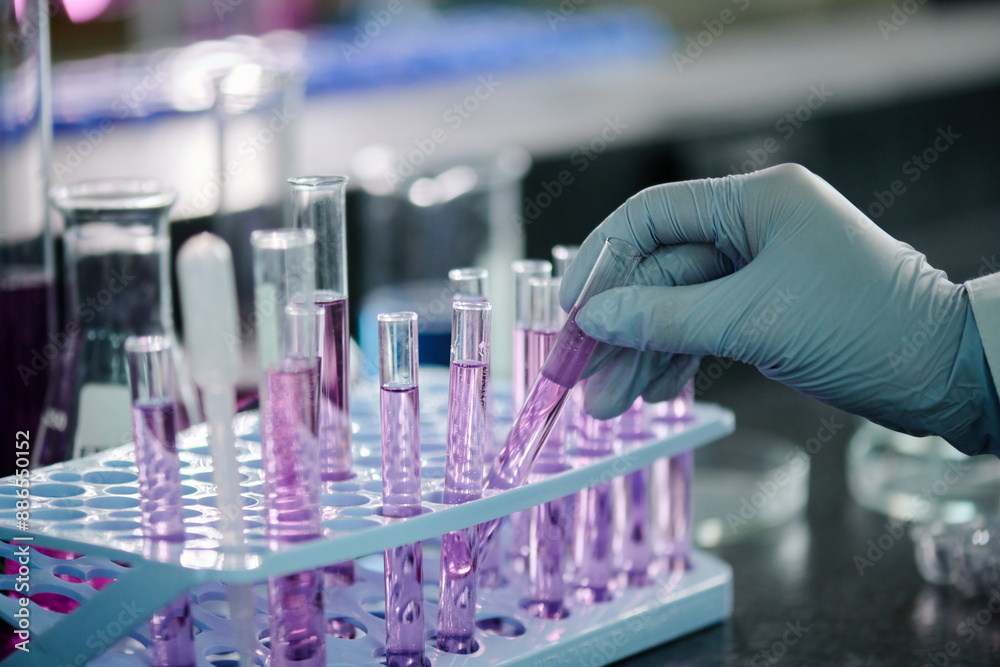 Poster gloved hand of modern chemist or clinician putting sample of purple liquid substance in stand with f