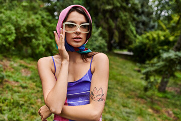 A beautiful young woman, dressed in vibrant attire, peacefully enjoying the summer breeze with a...