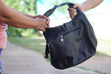 Thief hand  snatching the bag  from woman. Concept, Criminal pickpocket and crimes. Snatcher stealing  handbag. Steal  money wallet from other people, type of crime.  A thief who picks pockets.     