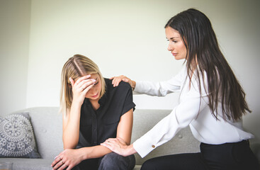 Psychotherapist supporting depressed teenage girl on couch during appointment in office a Psychotherapy concept