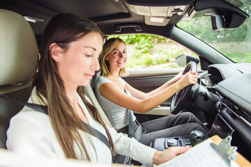 driver courses and people concept a car driving school instructor teaching young woman to drive