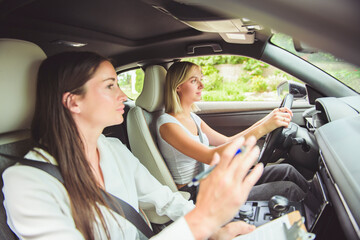driver courses and people concept a car driving school instructor teaching young woman to drive