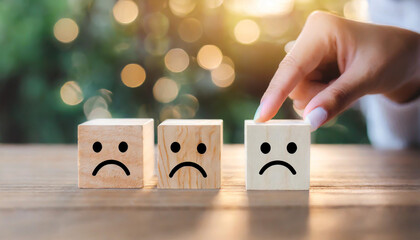 Close up customer hand choose smiley face and blurred sad face icon on wood cube, Service rating, satisfaction concept.
