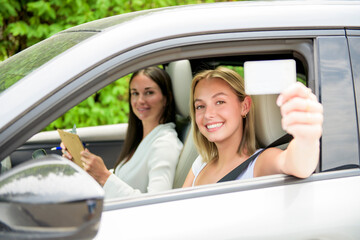 driver courses and people concept a car driving school instructor teaching young woman to drive