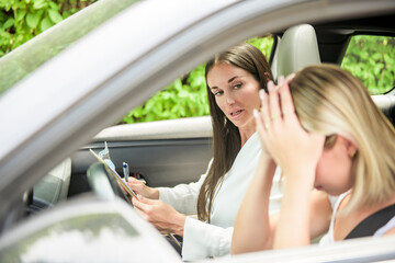 driver courses and people concept a car driving school instructor teaching young woman to drive