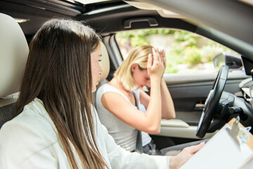 driver courses and people concept a car driving school instructor teaching young woman to drive