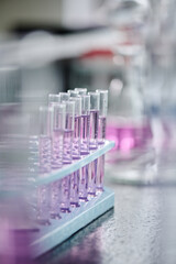 Focus on set of flasks containing purple liquid substance standing in front of camera on workplace of modern scientist or researcher