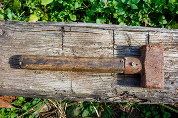 Old rusty sledgehammer lying on a log