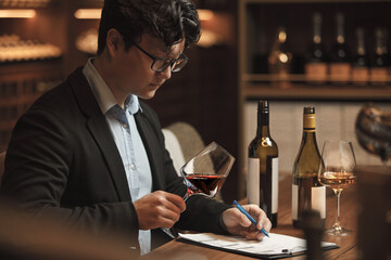Sommelier Writing Notes in Wine Cellar