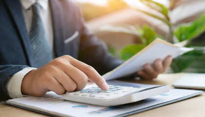 close up young man hand press on calculator to check and summary expense of home loan mortgage for refinance plan , people lifestyle concept