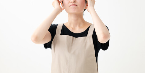 頭を抱えるエプロン姿の女性 © Peak River