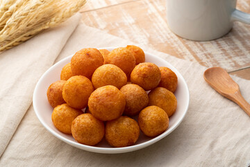 Thai Deep Fried Sweet Potato Balls in white plate. (Khanom khai nok kratha)