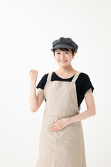 ガッツポーズをするエプロン姿の女性