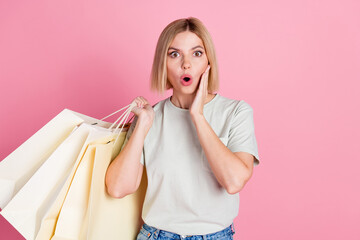 Portrait of speechless girl wear white t-shirt hold shopping bags arm on cheekbone astonished...