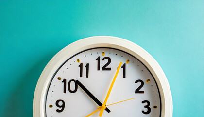 Part of white wall clock with yellow second hand hanging on wall. Close up image of plastic wall clock over turquiose blue background with copy space. Photo of time management or time is going concept