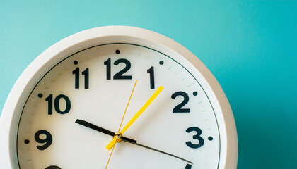 Part of white wall clock with yellow second hand hanging on wall. Close up image of plastic wall clock over turquiose blue background with copy space. Photo of time management or time is going concept