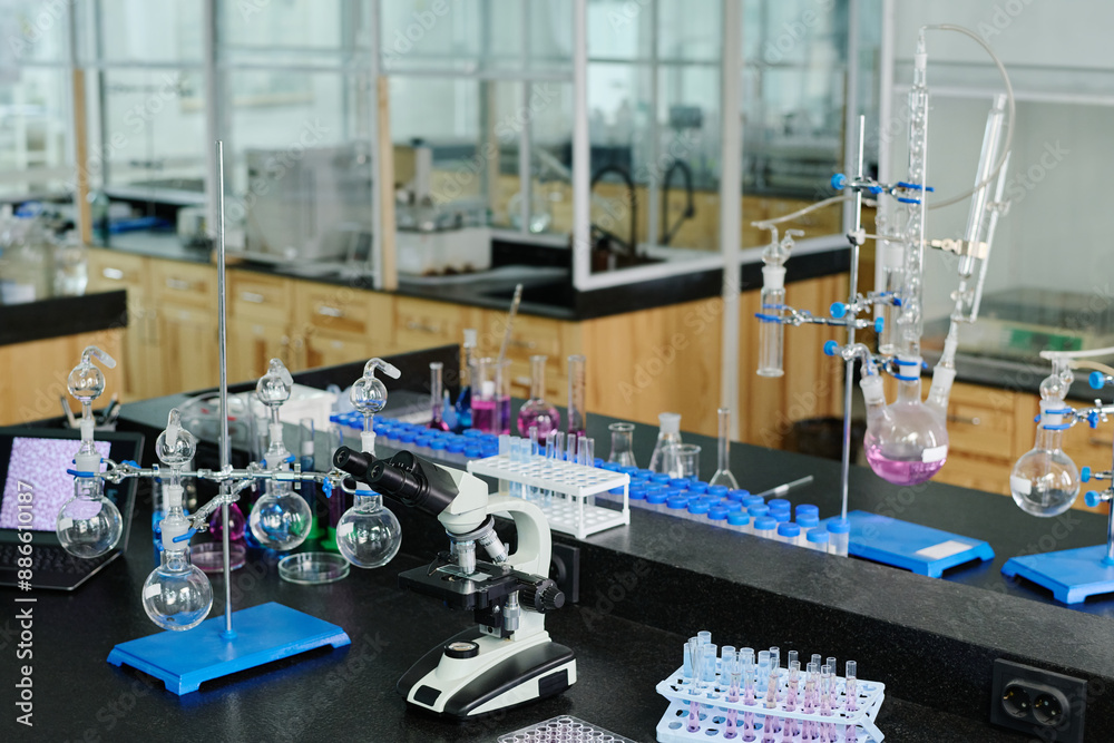 Poster various glassware, desktop computer and microscope standing on workplace of clinician or chemist in 