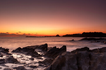 オレンジ色に染まる夕暮れの磯の風景