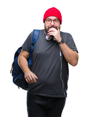 Naklejka premium Young hipster man wearing red wool cap and backpack over isolated background looking stressed and nervous with hands on mouth biting nails. Anxiety problem.