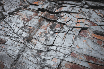 Closeup of grey slate rock formation texture with cracked pattern effect, natural stone background,...