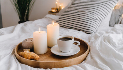 Hygge concept Coffee and candle filled wooden tray on a bed accompanied by white bedding striped blanket and pillow serving breakfast