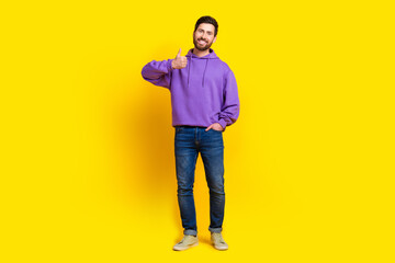 Full size photo of handsome young guy show thumb up wear trendy violet outfit isolated on yellow color background