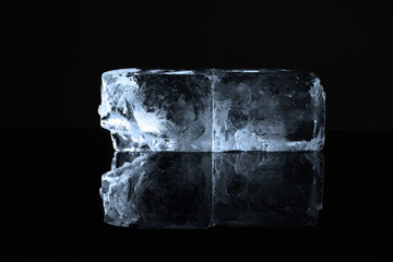 Blocks of clear ice on black mirror surface