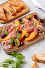 prosciutto or Parma ham or jamon serrano iberico with melon and olives traditional Italian appetizer antipasto 