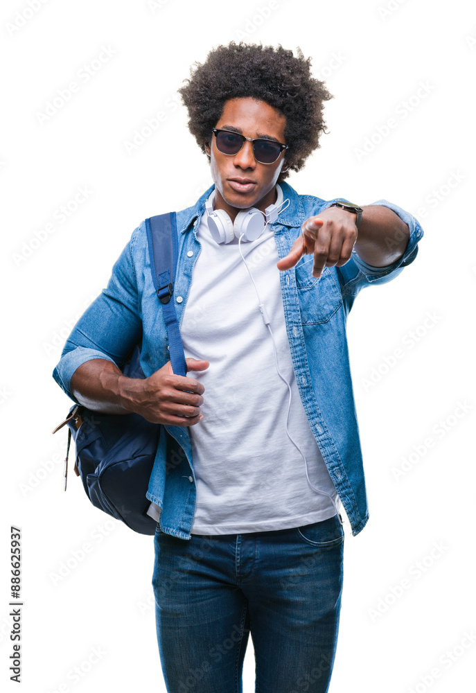 Canvas Prints Afro american man wearing headphones and backpack over isolated background pointing with finger to the camera and to you, hand sign, positive and confident gesture from the front